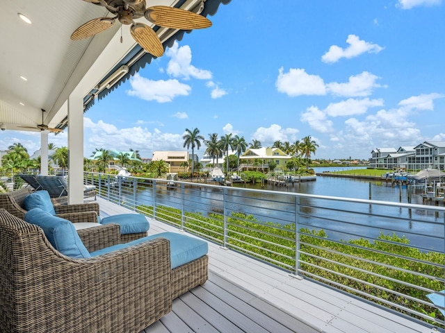 deck with a water view and ceiling fan