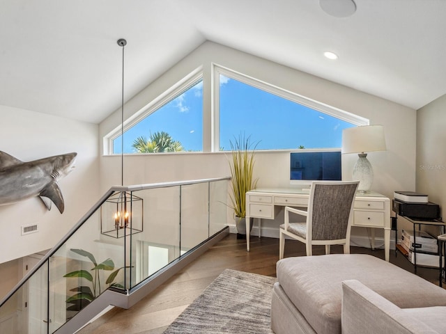 office area featuring hardwood / wood-style flooring, lofted ceiling, and a notable chandelier