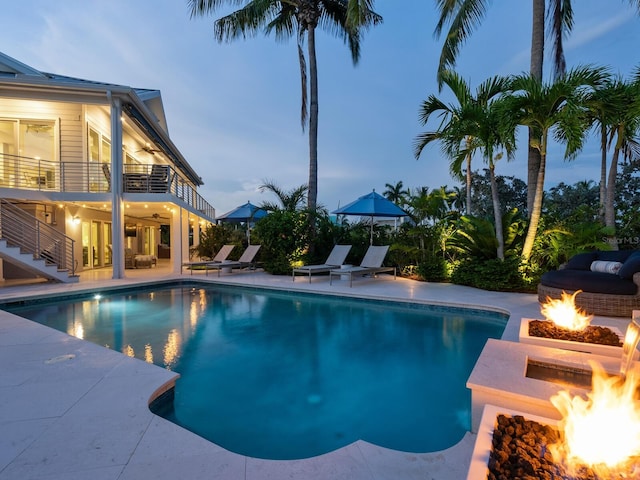 pool at dusk featuring a patio area and a fire pit