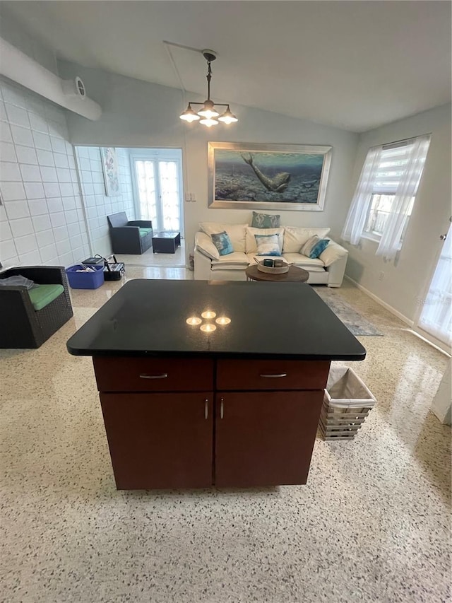 kitchen featuring tile walls, dark brown cabinetry, and lofted ceiling