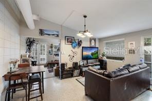 living room with lofted ceiling and an inviting chandelier