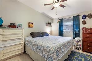 bedroom with lofted ceiling, ceiling fan, and light colored carpet