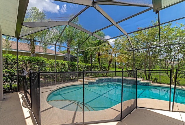 view of pool with a patio area and glass enclosure