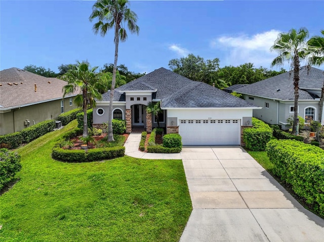 view of front of home with a garage, central AC, and a front yard