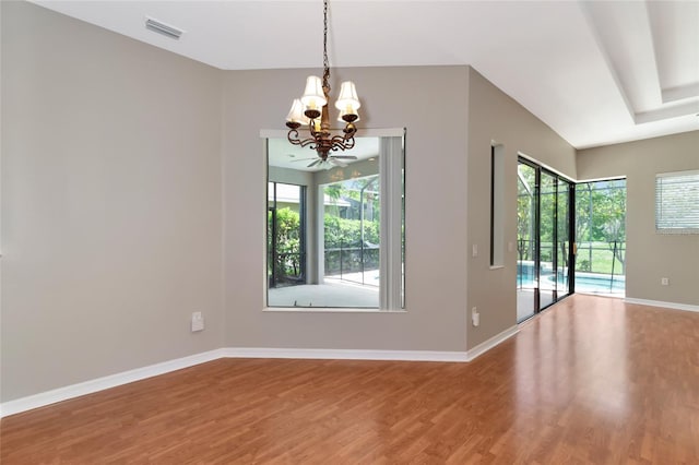 unfurnished dining area featuring hardwood / wood-style floors and a chandelier