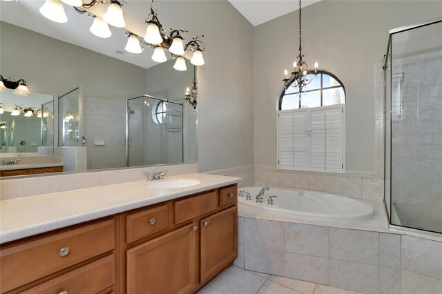 bathroom with tile patterned floors, plus walk in shower, vanity, and an inviting chandelier