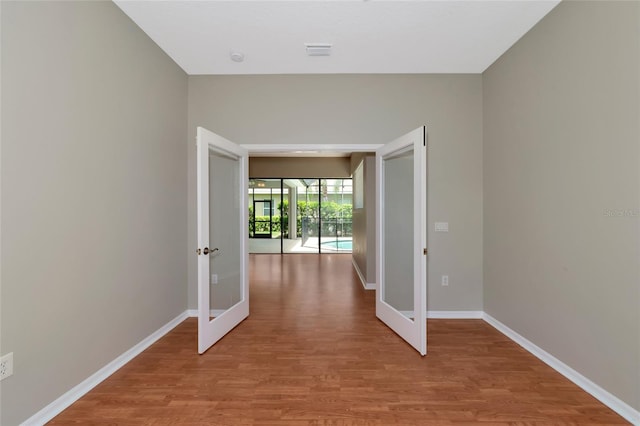 hallway featuring wood-type flooring and french doors