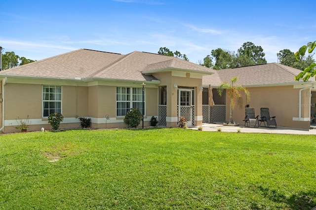 rear view of property featuring a patio and a lawn