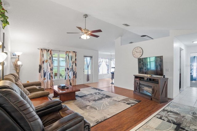 living room with tile patterned flooring, vaulted ceiling, and ceiling fan