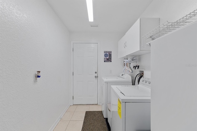 washroom featuring light tile patterned flooring, cabinets, and independent washer and dryer