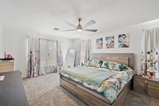 carpeted bedroom with a textured ceiling and ceiling fan