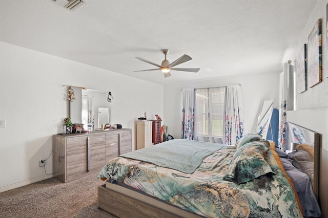 carpeted bedroom featuring a textured ceiling and ceiling fan