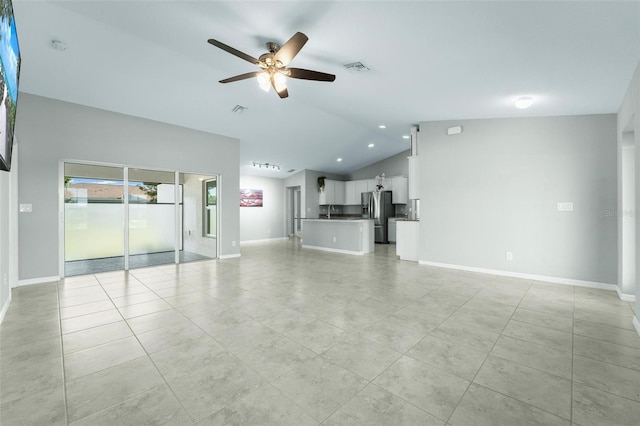 unfurnished living room featuring vaulted ceiling, light tile patterned floors, and ceiling fan