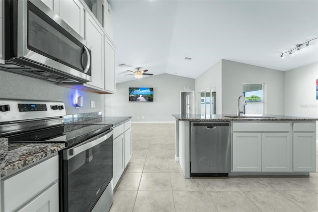 kitchen with white cabinets, ceiling fan, stainless steel appliances, track lighting, and vaulted ceiling