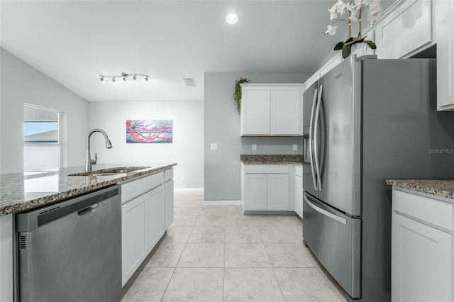 kitchen with white cabinetry, rail lighting, light tile patterned floors, stainless steel appliances, and sink