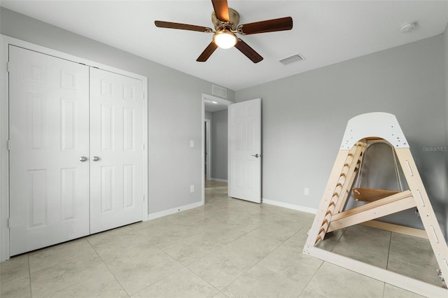 unfurnished bedroom featuring light tile patterned flooring, ceiling fan, and a closet