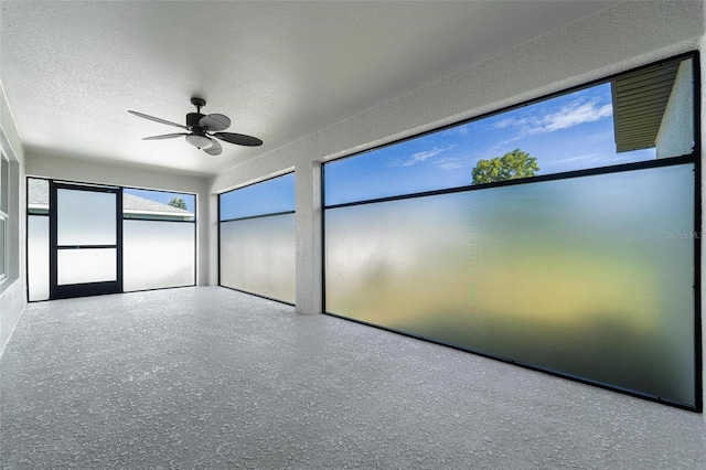 unfurnished sunroom with ceiling fan