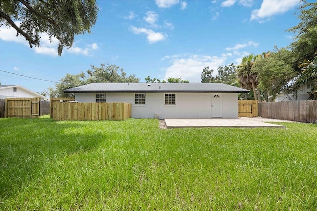 back of property with a lawn and a patio area