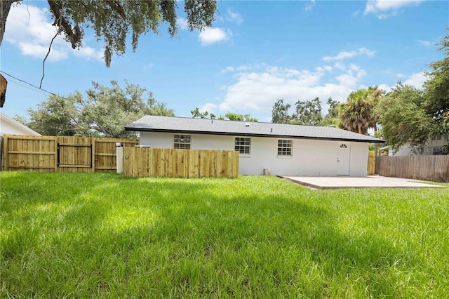 rear view of house with a patio and a yard