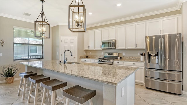 kitchen with appliances with stainless steel finishes, a kitchen island with sink, sink, pendant lighting, and white cabinets