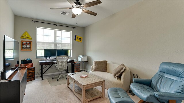 carpeted office space with ceiling fan