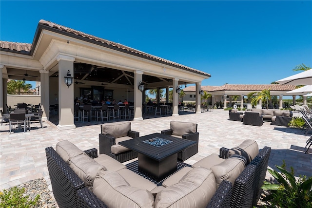 view of patio featuring exterior bar and an outdoor living space with a fire pit