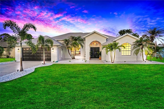 ranch-style house featuring a garage and a yard