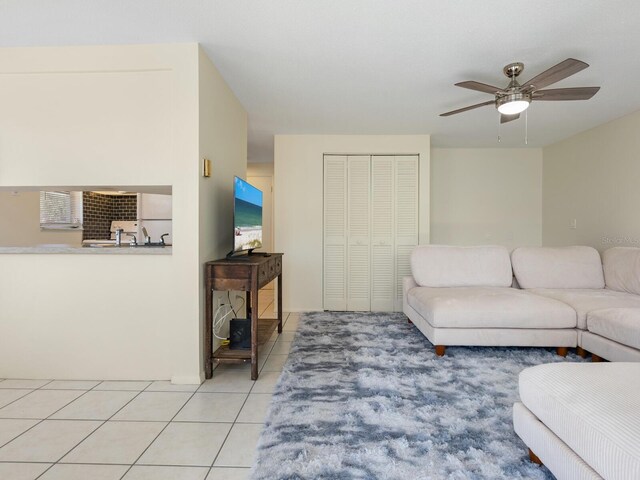 living room featuring light tile patterned floors and ceiling fan