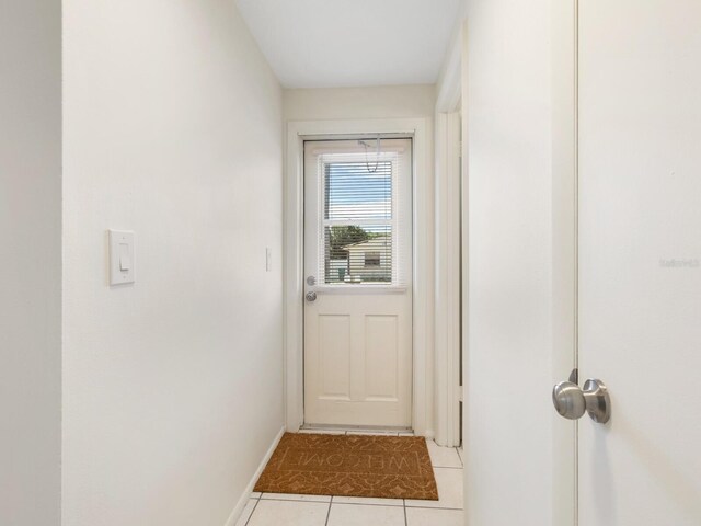 doorway to outside with light tile patterned floors