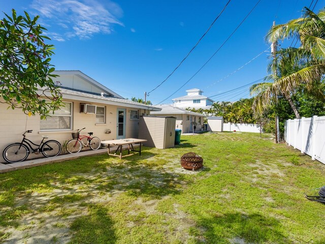 view of yard featuring a fire pit and a storage shed