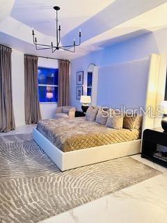 bedroom with a chandelier and a tray ceiling