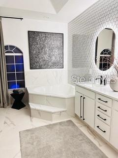 bathroom featuring tile patterned floors, vanity, and a tub to relax in