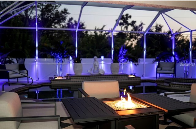 view of patio / terrace with glass enclosure and a fire pit