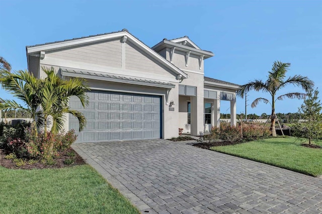 17931 Palmiste Dr, Bradenton, FL 34202 - view of front of property with an attached garage, decorative driveway, stucco siding, and a front yard