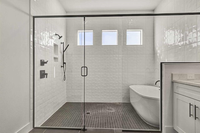 bathroom with tile patterned flooring, vanity, a healthy amount of sunlight, and separate shower and tub