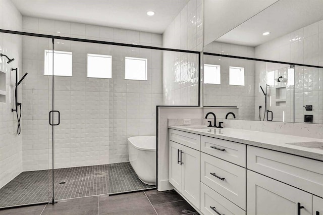 17931 Palmiste Dr, Bradenton, FL 34202 - bathroom featuring double vanity, a soaking tub, a stall shower, plenty of natural light, and recessed lighting