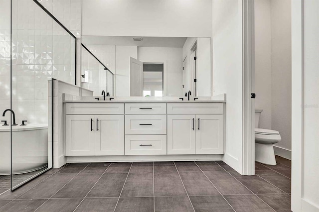 bathroom with tile patterned floors, vanity, toilet, and an enclosed shower