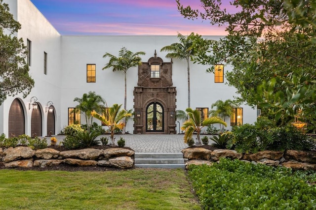 view of front facade featuring a lawn and french doors