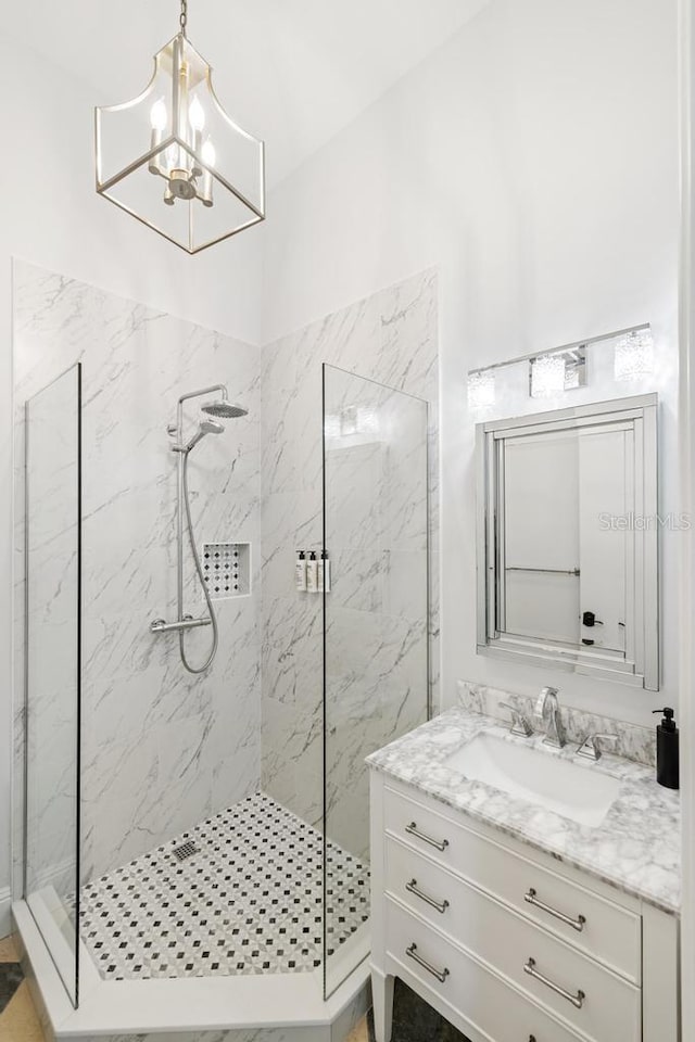 bathroom featuring vanity, a tile shower, and a chandelier