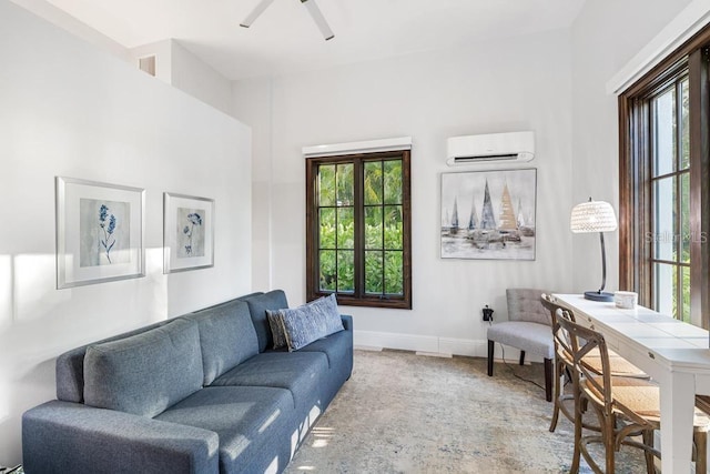 carpeted living room with a wall mounted AC and ceiling fan