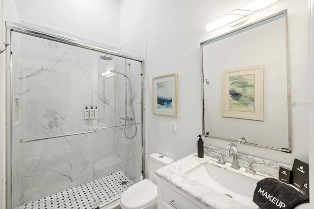 bathroom with vanity, toilet, and a shower with shower door