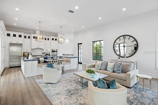 living room with an inviting chandelier and light wood-type flooring