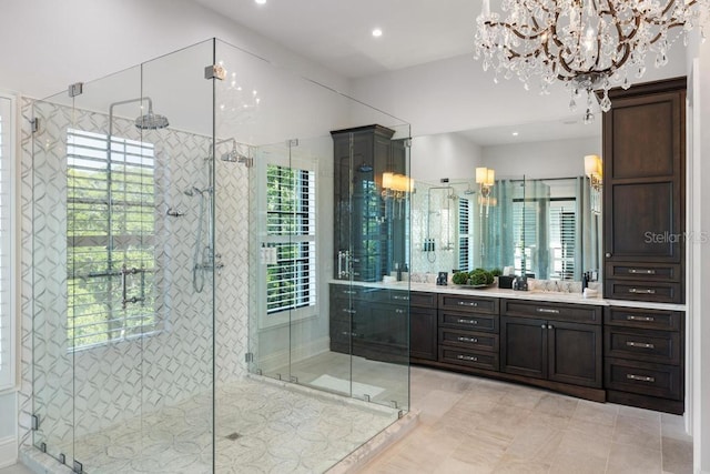 bathroom with tile patterned flooring, vanity, an inviting chandelier, and a shower with shower door