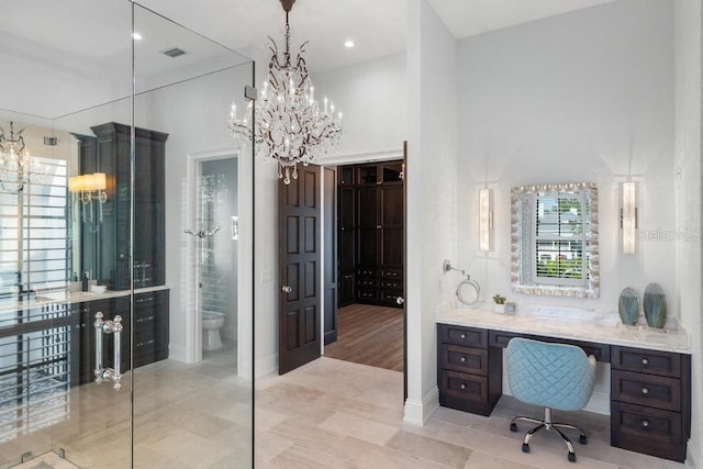 bathroom featuring vanity, a chandelier, and toilet