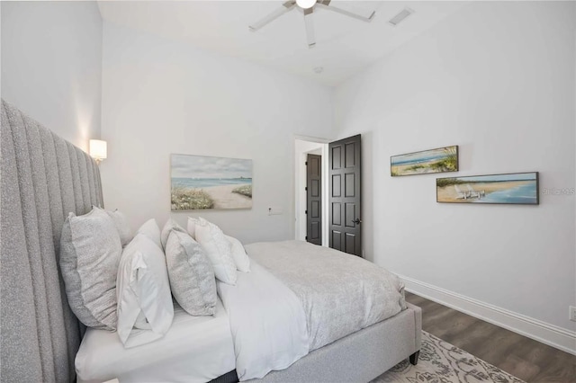 bedroom featuring ceiling fan, hardwood / wood-style floors, and a high ceiling