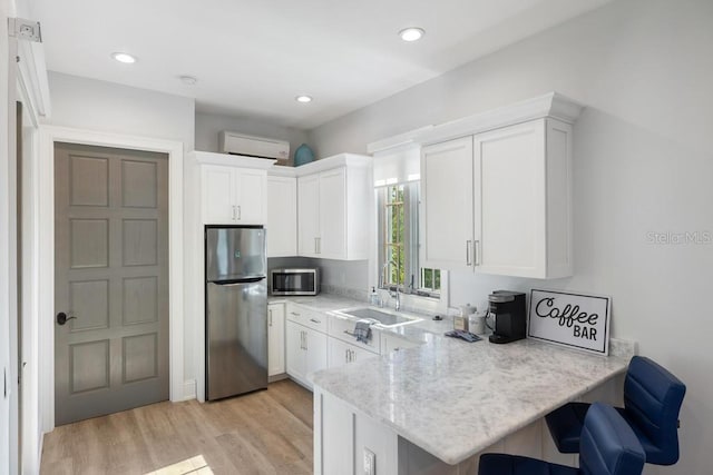 kitchen featuring white cabinets, kitchen peninsula, and appliances with stainless steel finishes