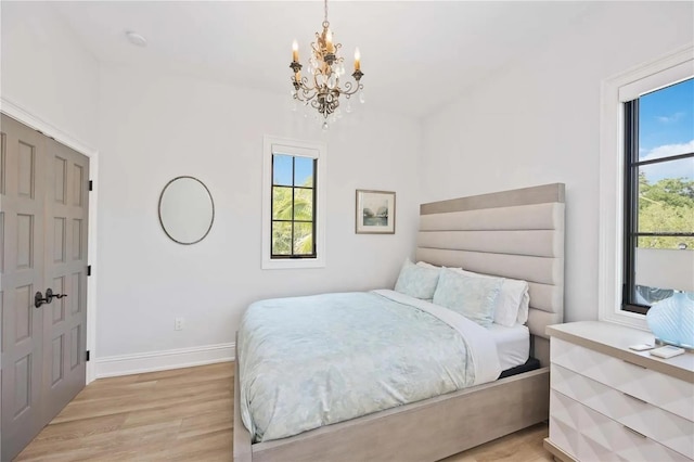 bedroom featuring light hardwood / wood-style flooring and a chandelier