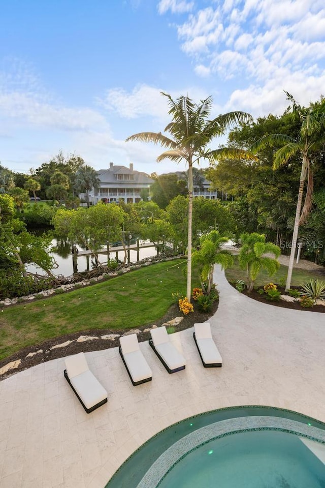 view of pool featuring a water view and a lawn