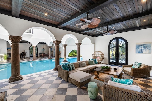 view of pool with french doors, ceiling fan, and decorative columns