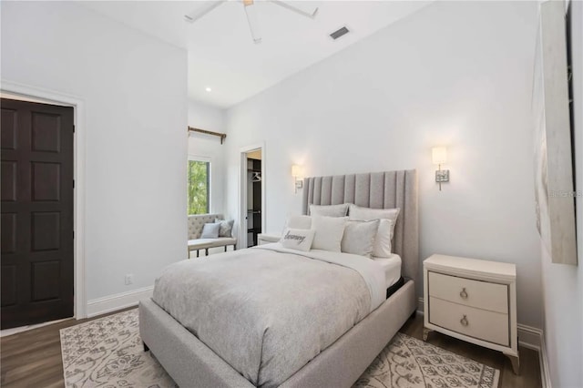 bedroom featuring hardwood / wood-style flooring, ceiling fan, and a spacious closet